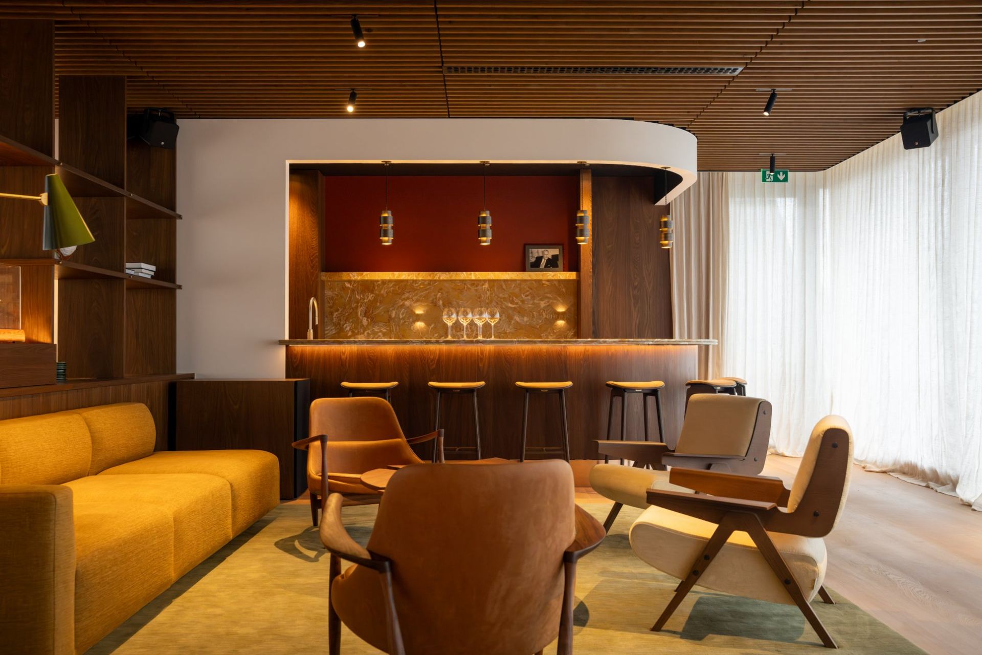 Loungezone met zicht op de bar met dieprode achterwand