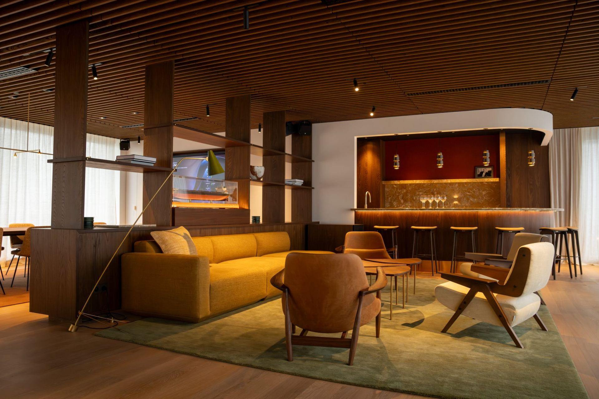 Lounge en bar gescheiden door een ruimtedelende maatwerk kastenwand