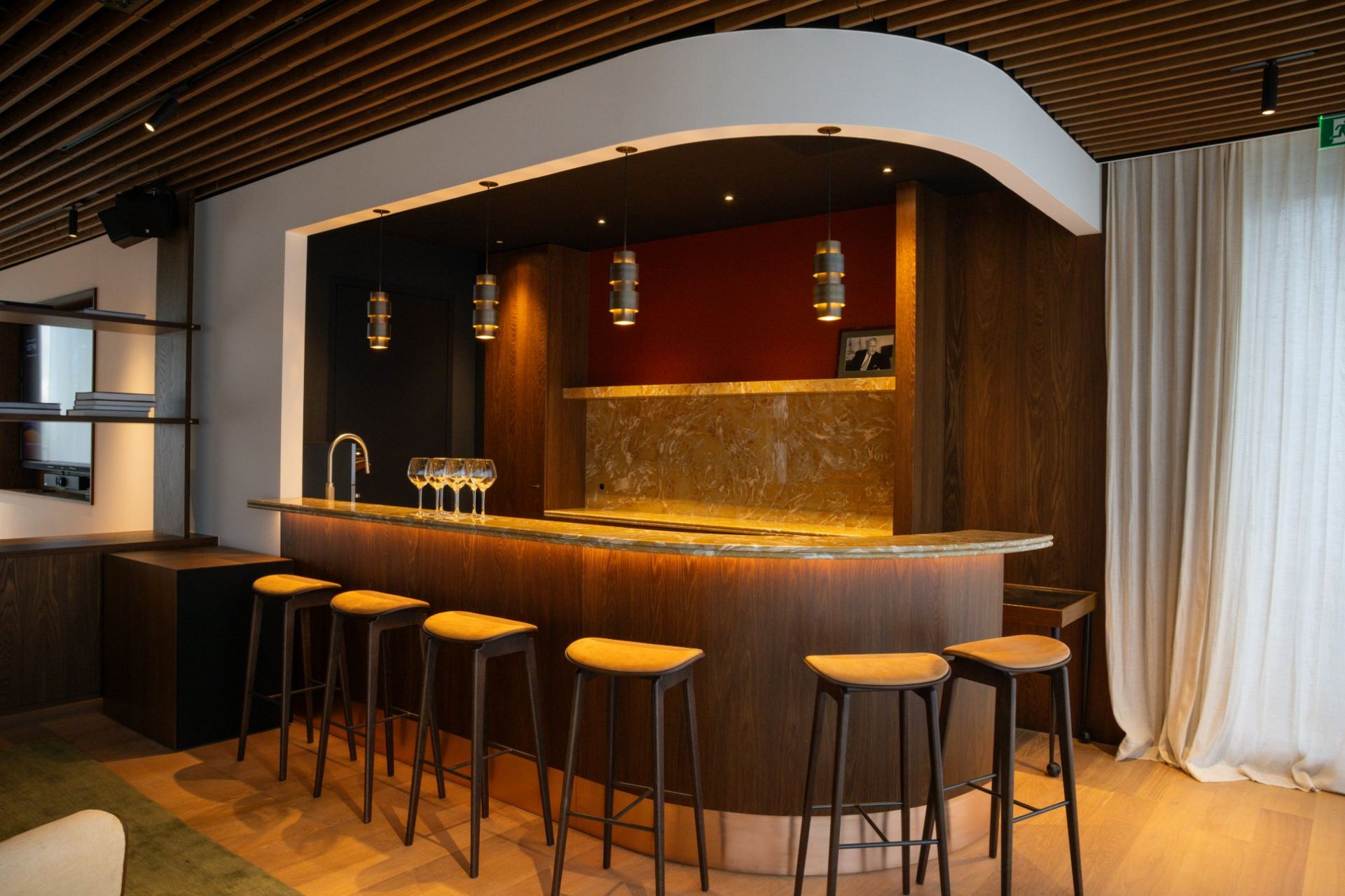 Ronde bar in gerookt eiken met verlicht natuurstenen blad en pendelverlichting